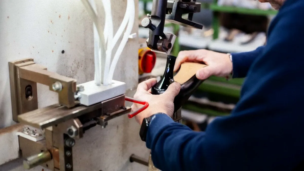 Un artigiano lavora una scarpa alla macchina nel laboratorio di Atelier Due Emme a Trani