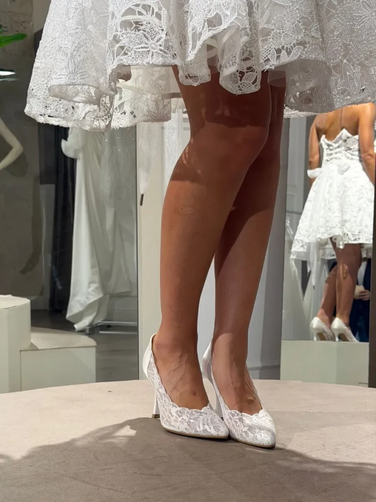 Décolleté in pizzo bianco indossata durante una prova con abito corto