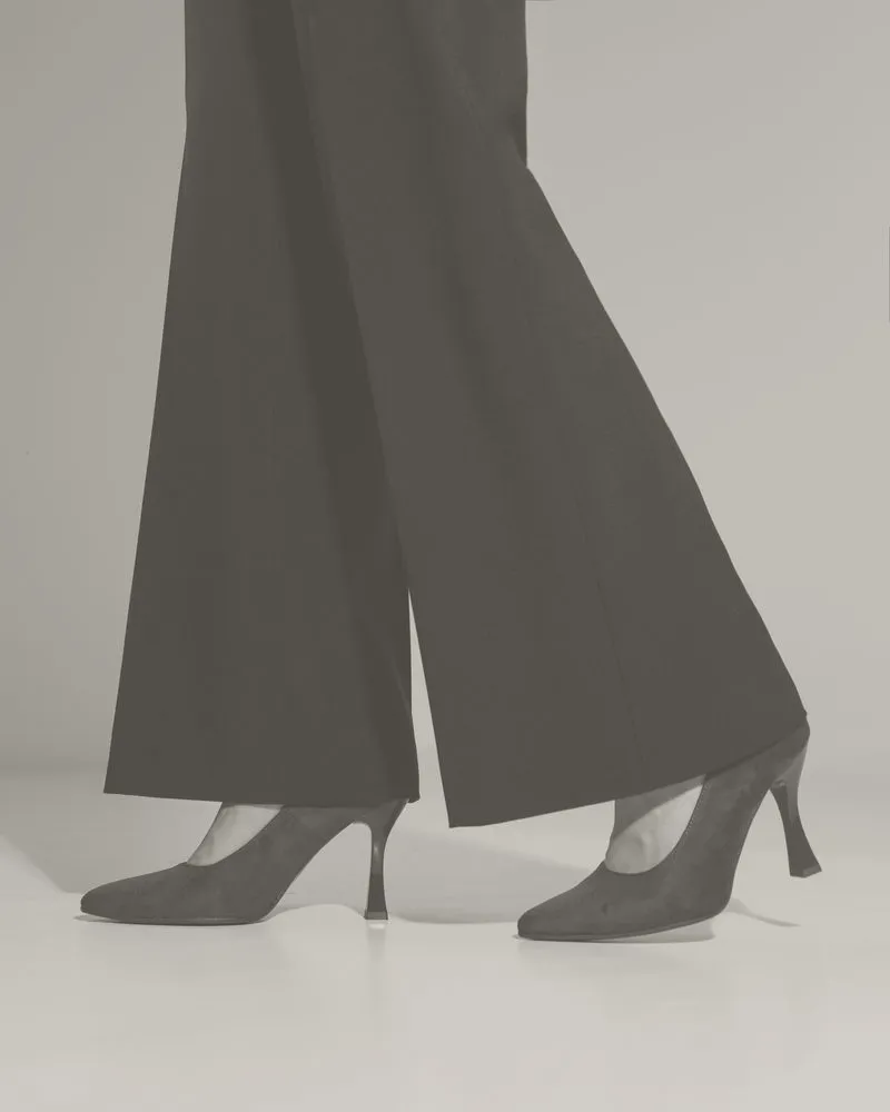 Décolleté scure sotto un pantalone nero a zampa: foto in bianco e nero
