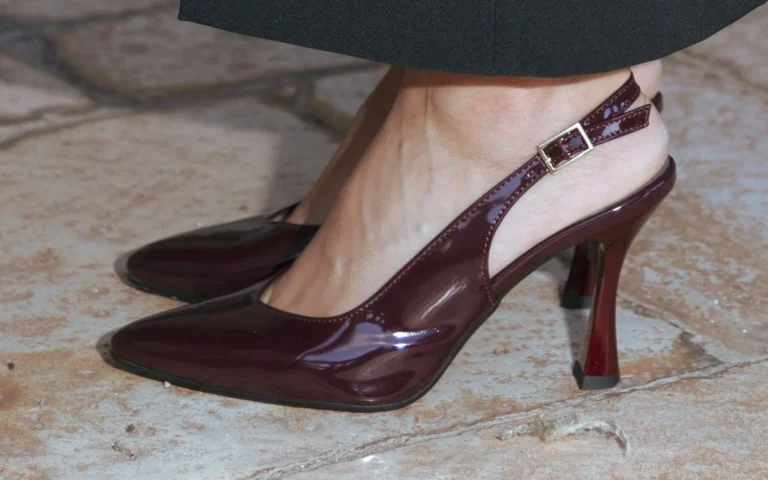 Slingback Etherea Bordeaux in vernice sotto un pantalone nero, su un pavimento di chianche
