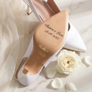 Suola in cuoio della slingback Etherea Sposa in raso bianco con i nomi Chiara e Luca, la data 18-06-2027, «Made in Italy» e il numero 38 in oro: immagine di presentazione