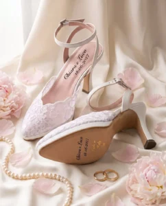 Coppia di décolleté da sposa Neve Sposa in pizzo bianco con i nomi Chiara e Luca e la data 18-06-2027 sul sottopiede e sulla suola, «Made in Italy» e numero in oro: immagine di presentazione