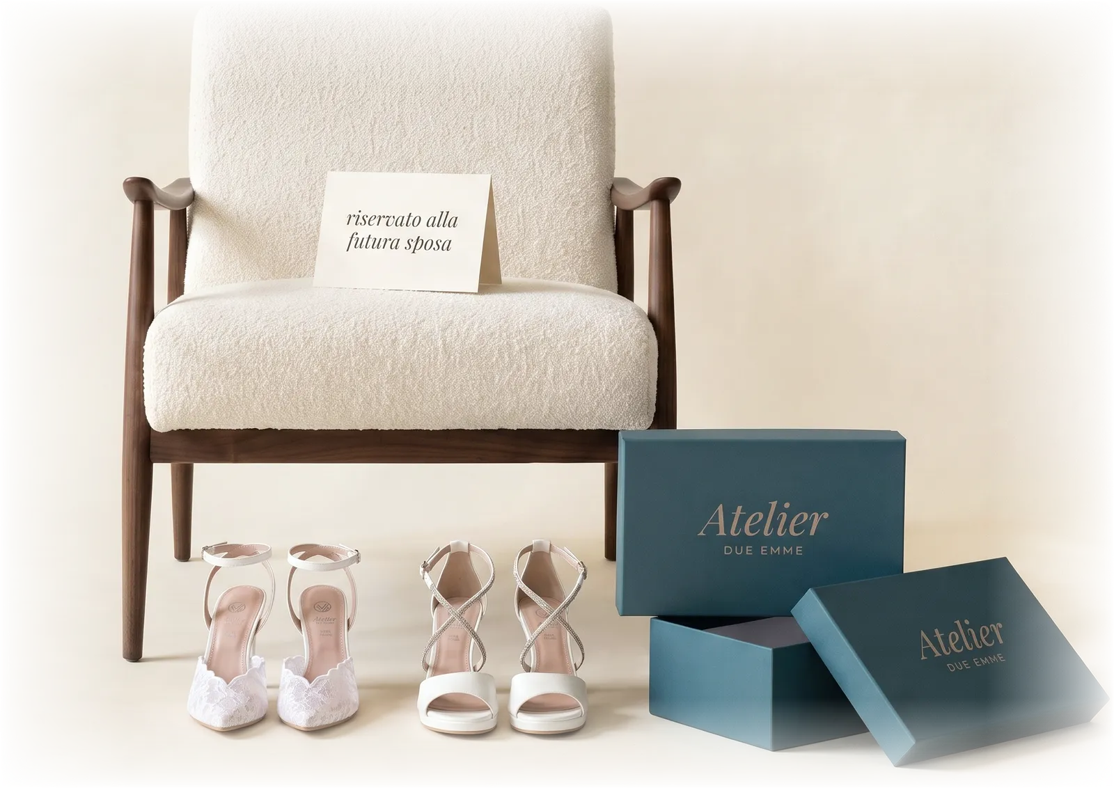 La poltrona riservata alla futura sposa nell'atelier di Trani: sul cuscino il cartellino «riservato alla futura sposa», davanti due paia di scarpe della collezione 2027 pronte per la prova, Adele in pizzo e Aurea Sposa con fasce di strass, e le scatole Atelier Due Emme in petrolio