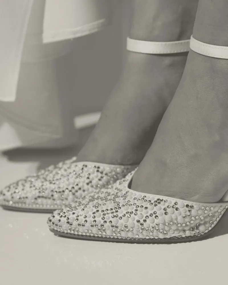 Punte di décolleté ricoperte di strass e perle, in primo piano: foto in bianco e nero