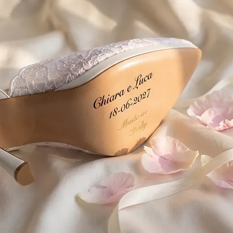 Suola in cuoio della décolleté da sposa Neve Sposa in pizzo bianco con i nomi Chiara e Luca, la data 18-06-2027, «Made in Italy» e il numero 38 in oro: immagine di presentazione